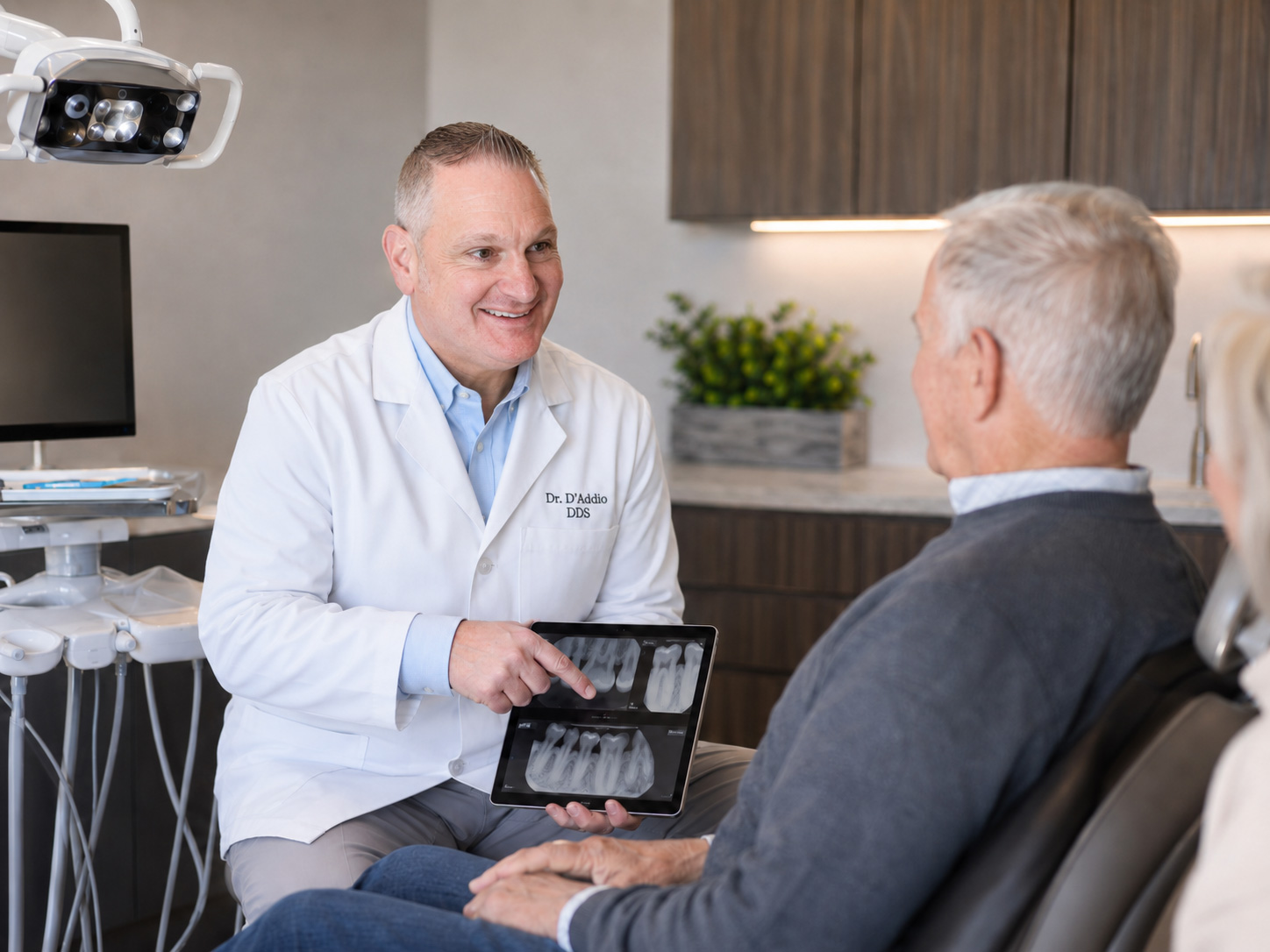Dr. D'Addio reviewing X-rays on a tablet with a senior patient at Dunning Family Dental.