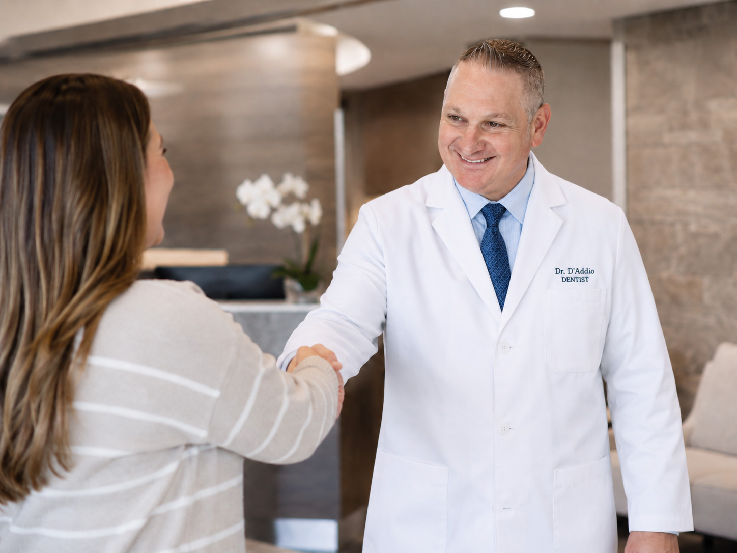 Dr. Anthony J. D'Addio greeting a returning patient in the front lobby of Dunning Family Dental in Johnstown, NY.
